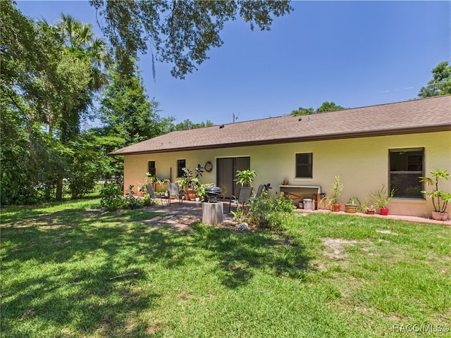 896 N Hollywood Cir, Crystal River, FL 34429 - back of property with stucco siding, a patio, and a lawn