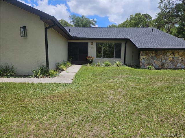 property entrance with a lawn