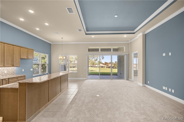 kitchen with hanging light fixtures, light colored carpet, tasteful backsplash, and ornamental molding