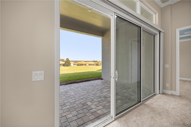 doorway featuring light colored carpet and ornamental molding