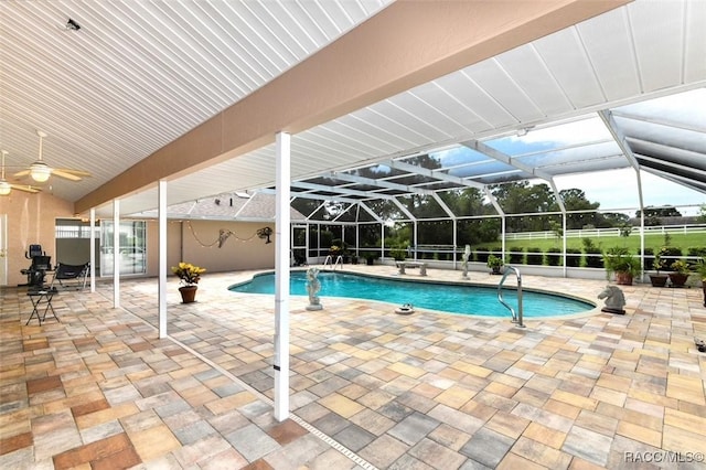 view of pool featuring glass enclosure and a patio