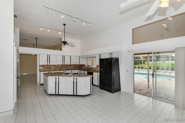 kitchen featuring ceiling fan, a kitchen island, decorative backsplash, white cabinetry, and black fridge with ice dispenser