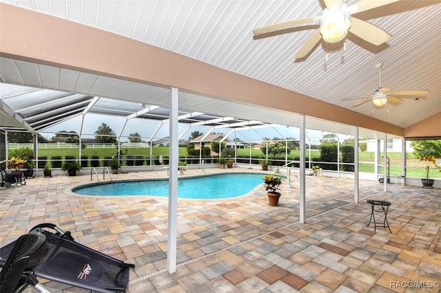 view of swimming pool featuring ceiling fan, glass enclosure, and a patio