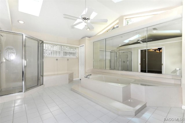 bathroom featuring ceiling fan, vaulted ceiling with skylight, plus walk in shower, and tile patterned flooring