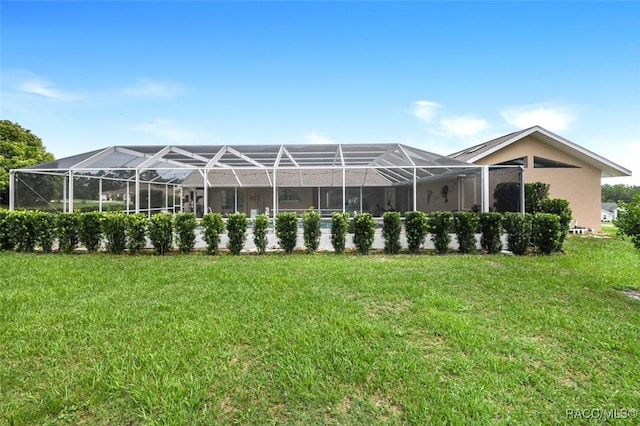 rear view of house featuring a lanai and a yard