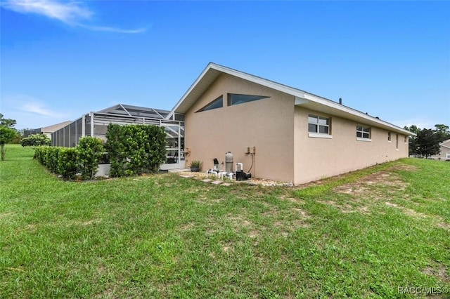 view of property exterior featuring a lanai and a lawn