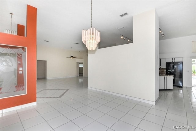 interior space featuring light tile patterned floors and ceiling fan with notable chandelier