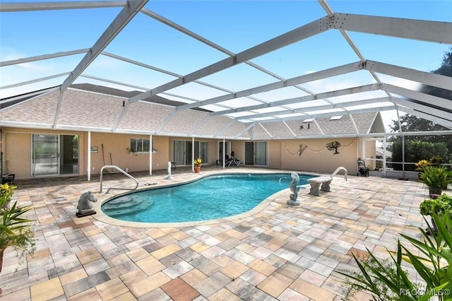 view of pool featuring glass enclosure and a patio area