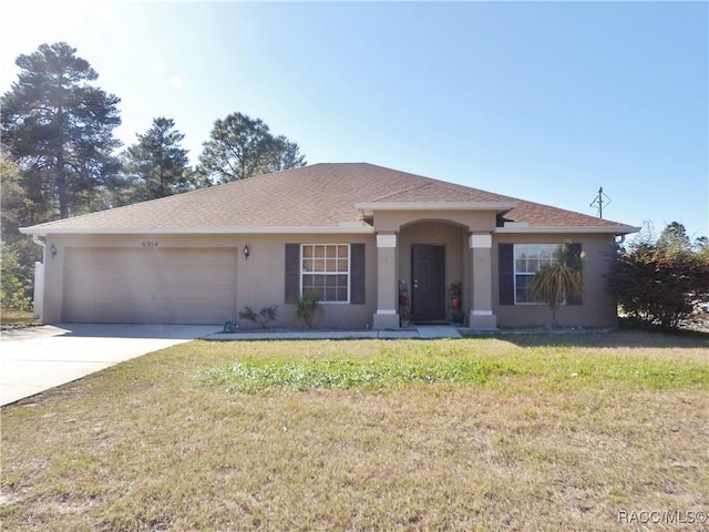 view of front of property featuring a garage and a front lawn