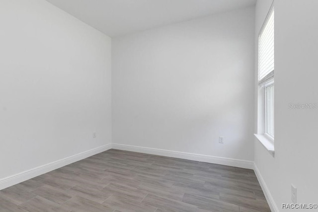 spare room featuring light hardwood / wood-style flooring and a healthy amount of sunlight