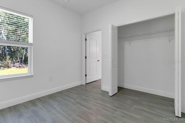 unfurnished bedroom with wood-type flooring and a closet