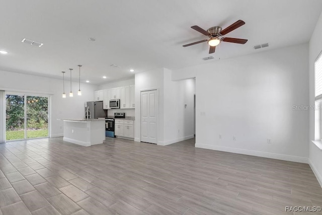 unfurnished living room with ceiling fan and light wood-type flooring