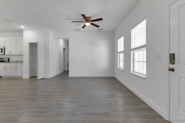 unfurnished living room featuring ceiling fan and light hardwood / wood-style floors