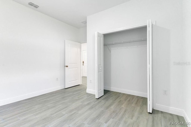 unfurnished bedroom featuring a closet and light wood-type flooring