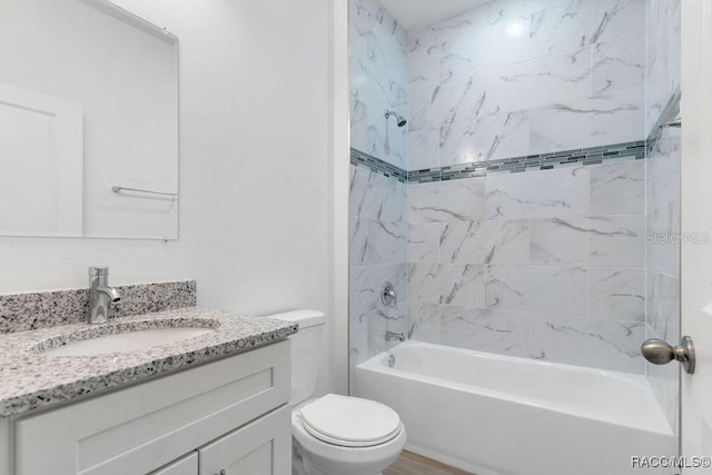 full bathroom with toilet, vanity, and tiled shower / bath