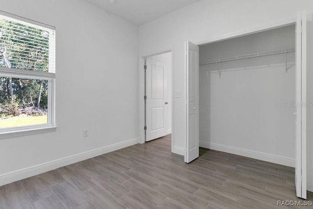 unfurnished bedroom featuring wood-type flooring and a closet