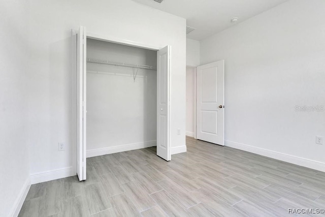 unfurnished bedroom with a closet and light hardwood / wood-style flooring