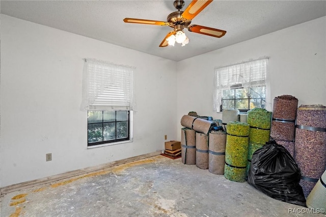 interior space with a textured ceiling, concrete floors, and ceiling fan