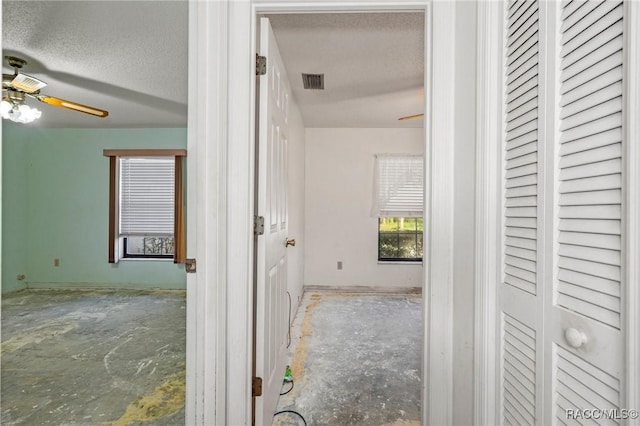 hall with a textured ceiling