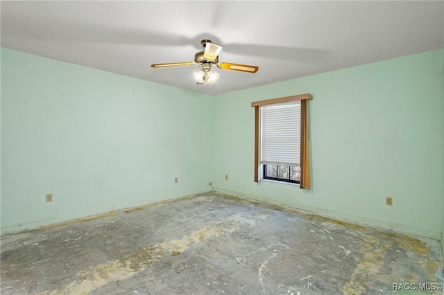 spare room featuring ceiling fan and concrete floors