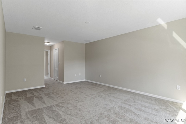 spare room featuring light colored carpet