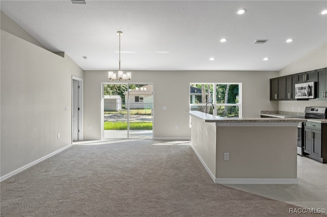 kitchen featuring lofted ceiling, stainless steel appliances, hanging light fixtures, and a healthy amount of sunlight