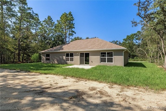 rear view of property with a yard and a patio