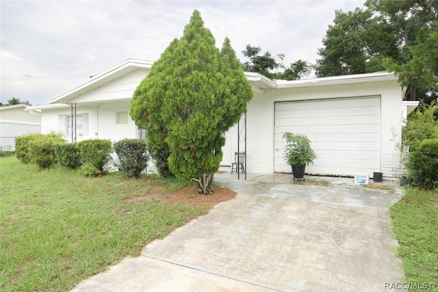 ranch-style home featuring a front lawn and a garage