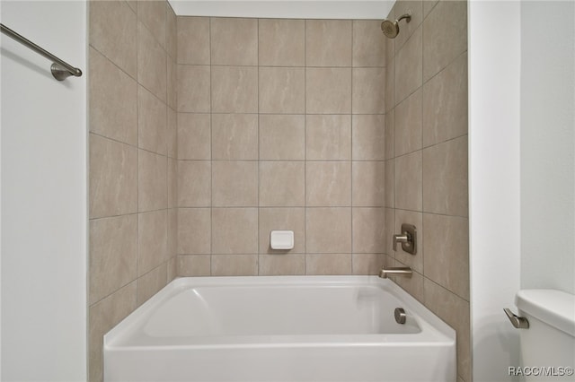 bathroom with tiled shower / bath combo and toilet