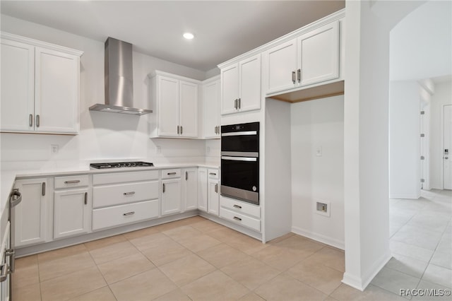 kitchen featuring black double oven, white cabinetry, wall chimney exhaust hood, and stainless steel gas cooktop