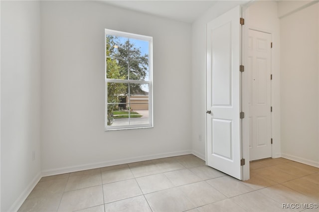 unfurnished room featuring a healthy amount of sunlight and light tile patterned floors