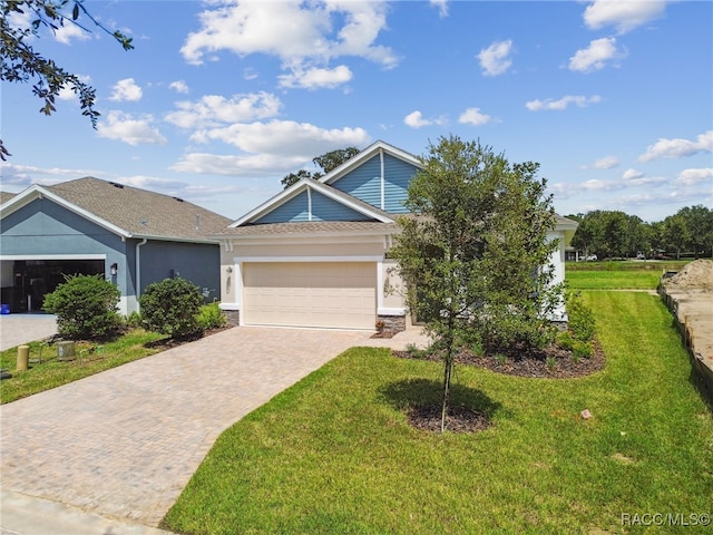 view of front of home with a front yard and a garage