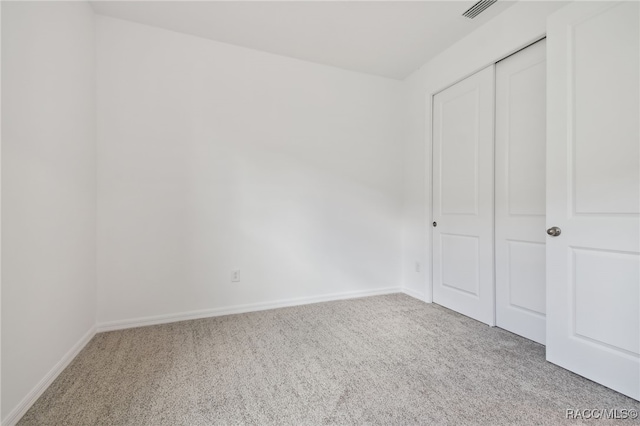 unfurnished bedroom with a closet and carpet floors