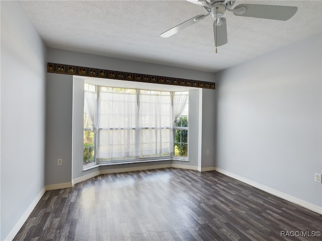 spare room with a textured ceiling, ceiling fan, and dark wood-type flooring