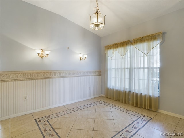 unfurnished room featuring tile patterned floors and lofted ceiling