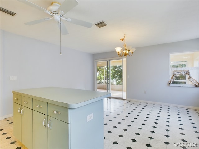 kitchen with pendant lighting, ceiling fan with notable chandelier, and a kitchen island