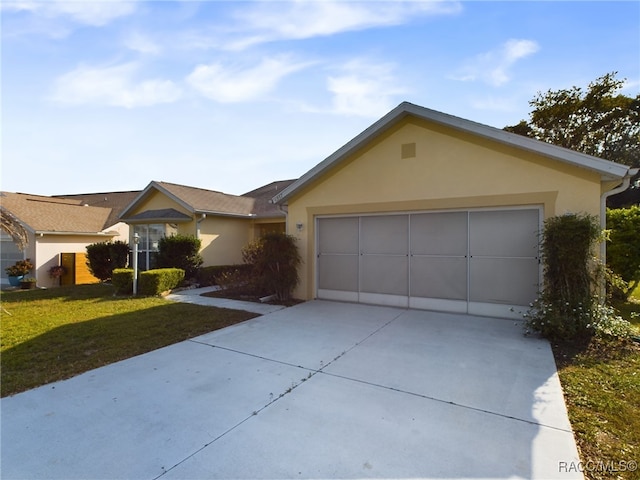 ranch-style house featuring a front lawn and a garage