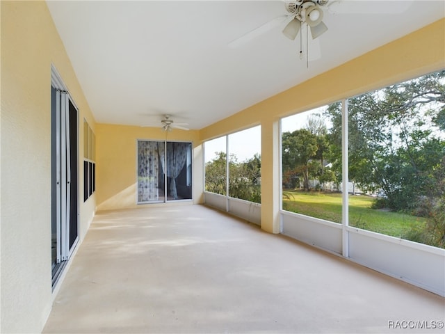 unfurnished sunroom featuring ceiling fan