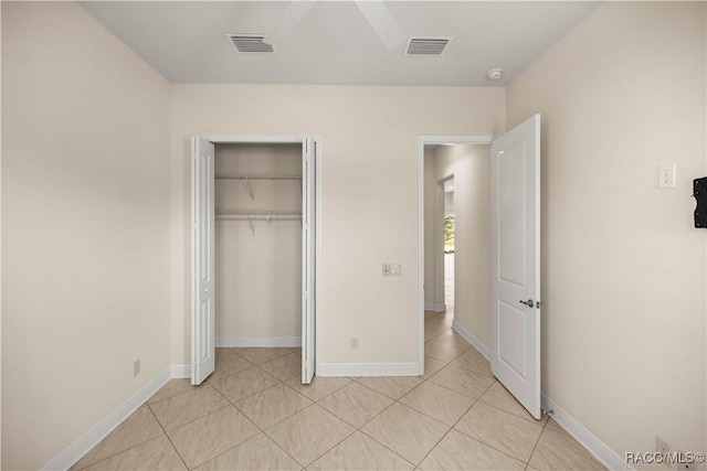 unfurnished bedroom with light tile patterned floors and a closet