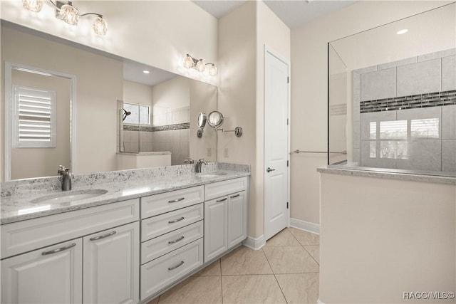 bathroom featuring tiled shower and vanity