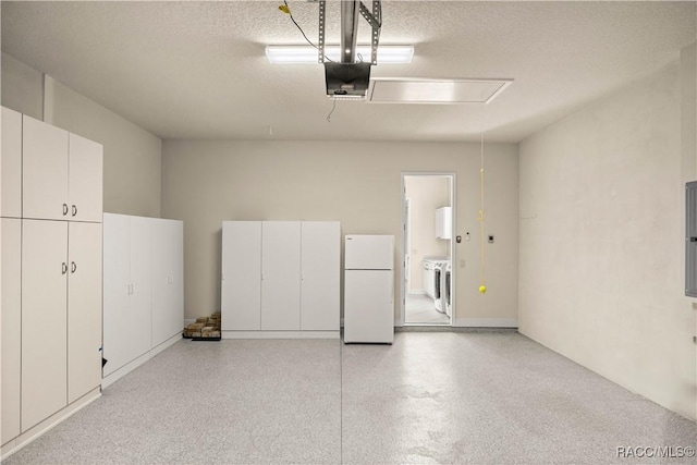 garage featuring separate washer and dryer, a garage door opener, electric panel, and white fridge