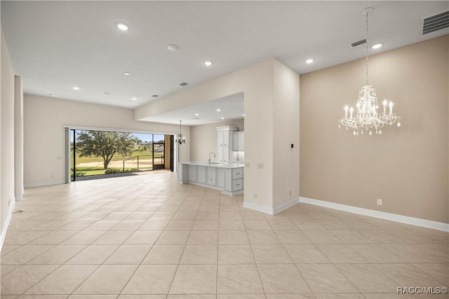 unfurnished living room with light tile patterned flooring and an inviting chandelier