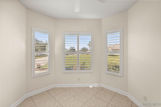 spare room featuring ceiling fan, a healthy amount of sunlight, and light tile patterned floors