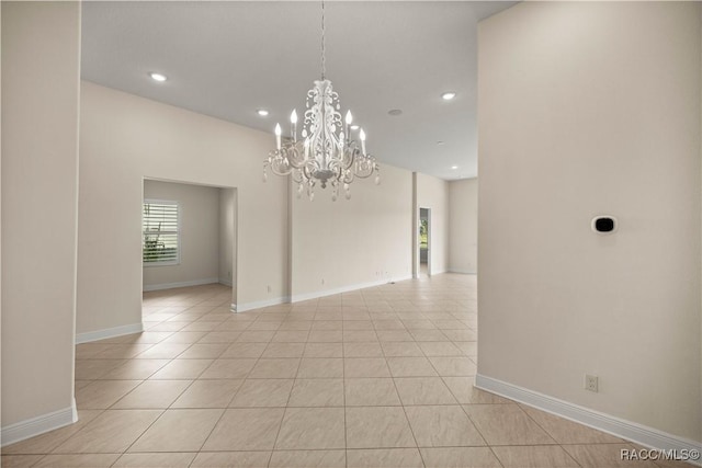 tiled empty room with an inviting chandelier