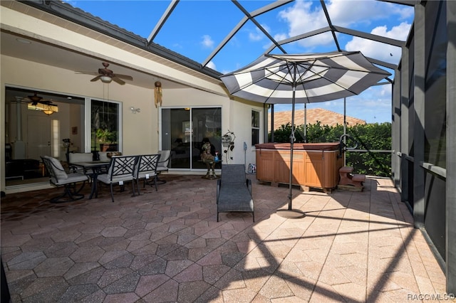 view of patio featuring a mountain view, a hot tub, ceiling fan, and a lanai