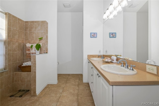 bathroom featuring tile patterned flooring, vanity, and tiled shower