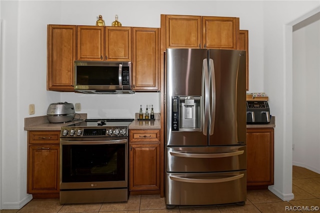 kitchen featuring light tile patterned floors and stainless steel appliances