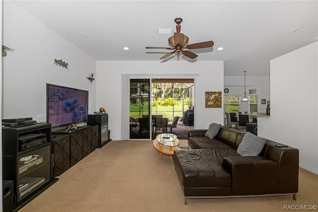 carpeted living room with ceiling fan