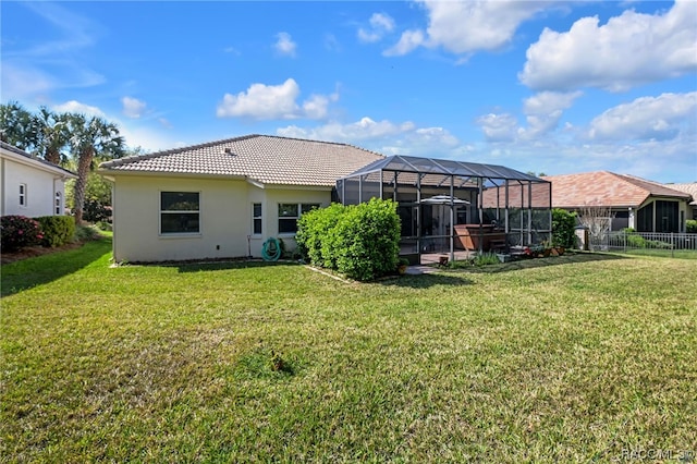 back of property with a lawn and glass enclosure