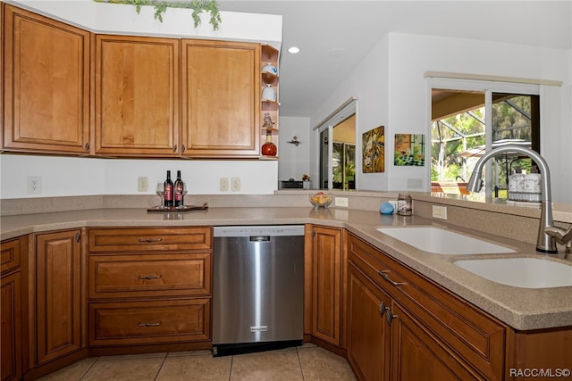 kitchen with light tile patterned floors, stainless steel dishwasher, and sink